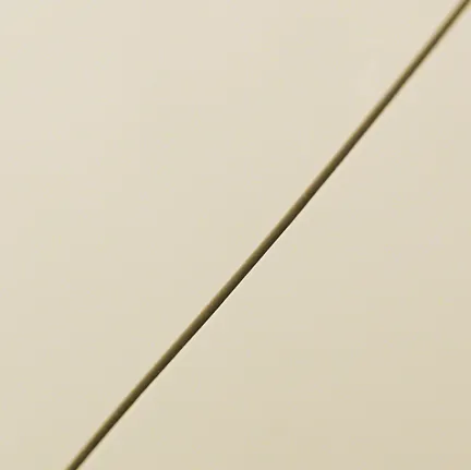 Close-up of a straight cut line on a smooth beige tile.