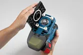 Person holding a cordless orbital sander with the base plate removed.