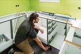 A person installs cabinetry while using a digital inclinometer on the counter.