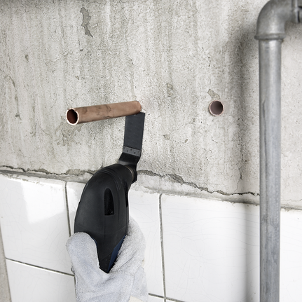 3-piece basic tile set A worker wearing safety equipment cuts through a copper pipe in a tiled wall.