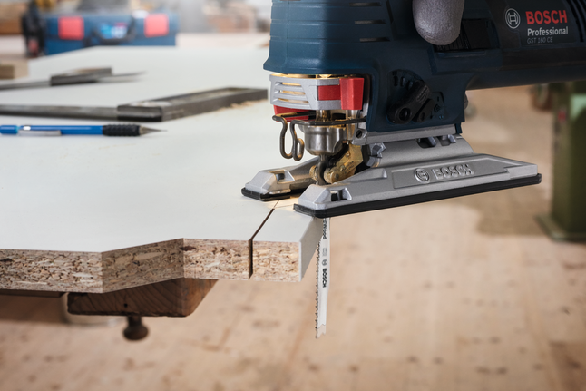 Jigsaw blade T 101 B Gloved worker uses a jigsaw to cut a precise line through laminated wood.