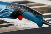 Close-up of a textured ergonomic power tool handle with a visible trigger.