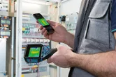 Person uses a thermo camera and smartphone to check heat patterns in an electrical panel.