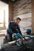 Man using electric miter saw.