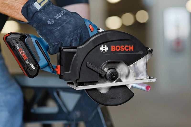 GKM 18V-50 A person wearing safety equipment cuts a metal pipe with a cordless circular saw.