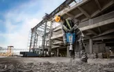 Worker using jackhammer onsite.