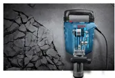 Jackhammer breaking concrete surface.