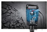 Jackhammer breaking concrete surface.
