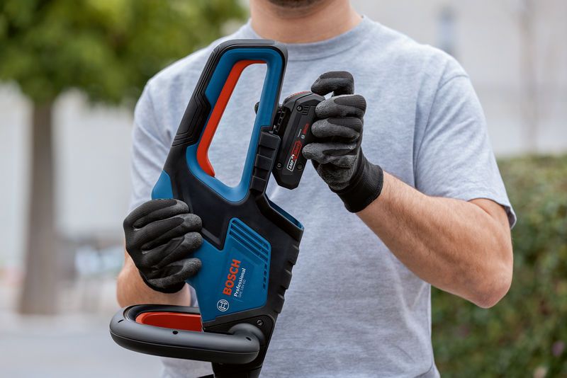 GHE 18V-60 Person wearing safety equipment inserts a battery into a cordless power tool.