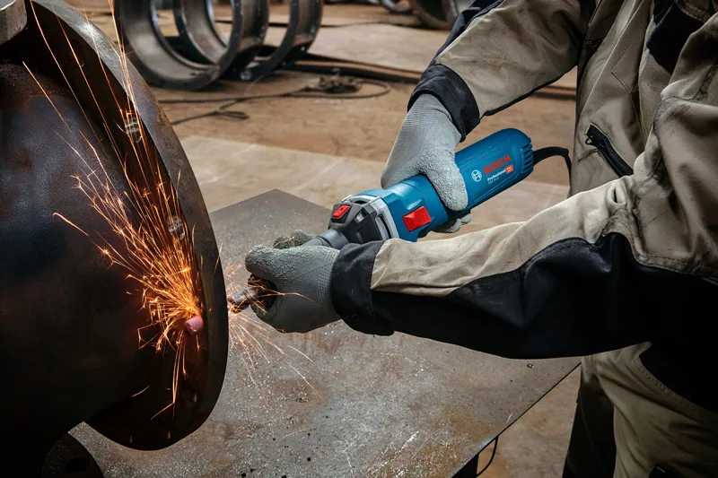 GGS 30 LS A person wearing safety equipment grinds metal, creating bright sparks.
