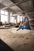 Bosch GBL 650 blower clearing sawdust from a workbench.