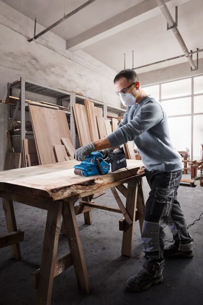 Bosch GBS 750 belt sander smoothing wooden plank.