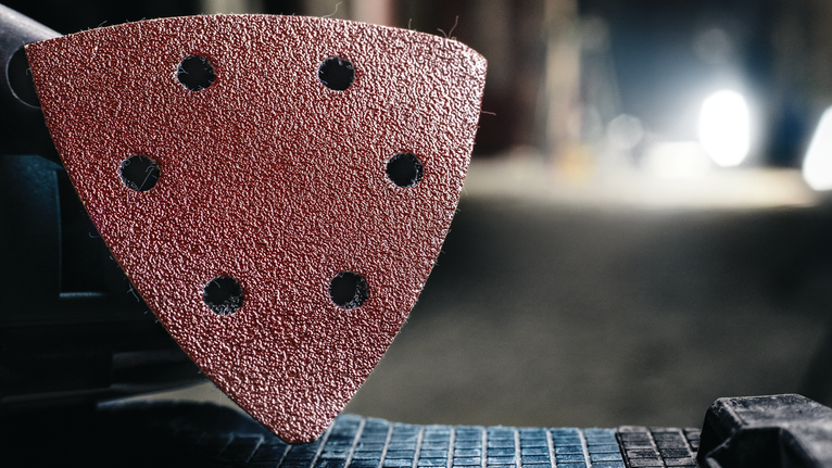 PRO F460 Sanding Sheet, 93 x 93 mm, G60, G80, G120, G180, G240, 10 pcs Detail view of a triangular sanding pad attached to a power tool.