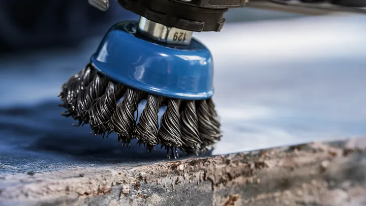 Object #200456905: 3089943_app_web_2 Wire brush attachment cleaning rust from the edge of a metal surface.