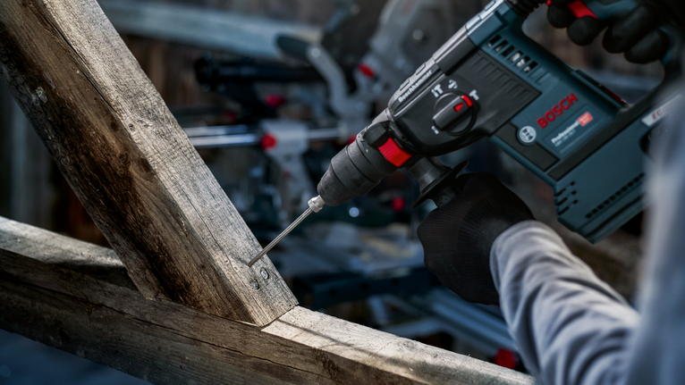 PRO SDS plus Rod Driver, 58 mm Person wearing safety equipment drills into a wooden beam.