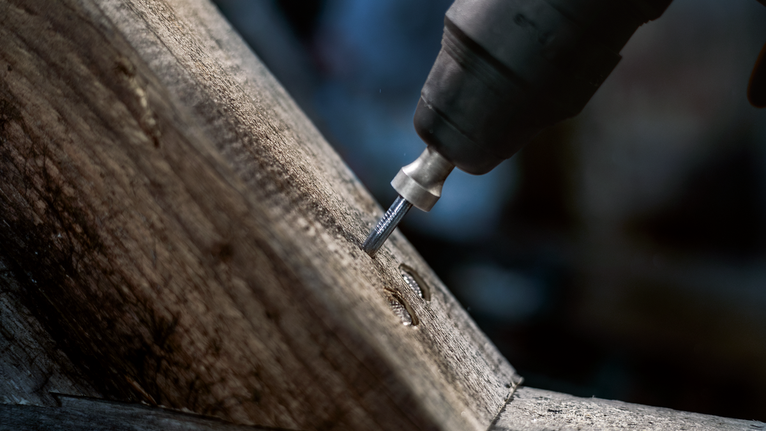 PRO SDS plus Rod Driver, 58 mm Rotary tool grinding a groove into a wooden beam.