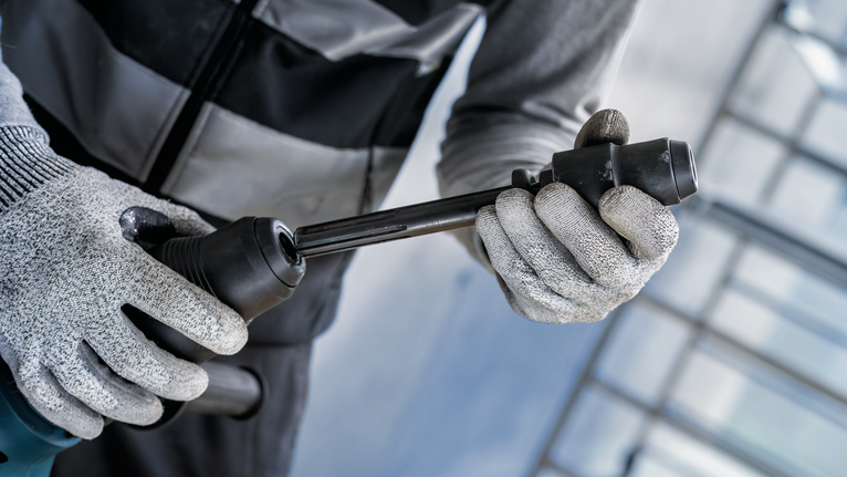 PRO Hammer Adapter, SDS max to SDS plus Person wearing safety equipment inserts a drill bit into a rotary hammer.