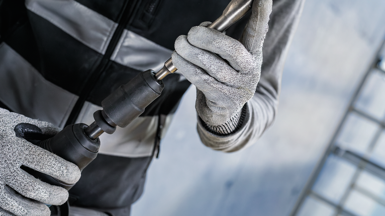 PRO Hammer Adapter, SDS max to SDS plus Person wearing safety equipment attaches a drill bit to a power tool.