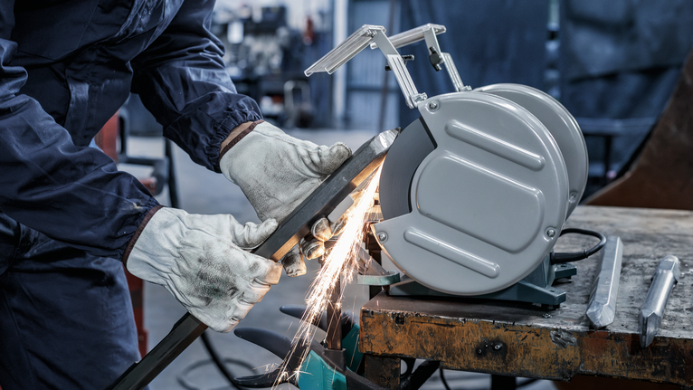 PRO Metal Grinding Wheel, 200 x 25 x 32 mm, G60 A person wearing safety equipment grinds metal, producing sparks on a workbench.