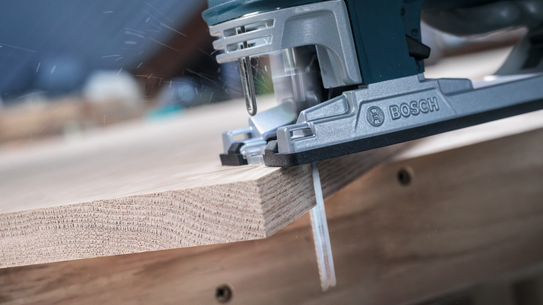 PRO Hardwood clean T101BF Jigsaw Blade, 100 mm, 5 pcs Jigsaw cutting through a wooden board in a workshop.