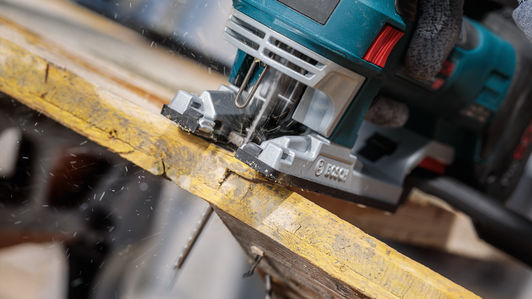 PRO Multi Material thick and thin T345XF Jigsaw Blade, 132 mm, 3 pcs Person wearing safety equipment uses a jigsaw to cut a wooden board.