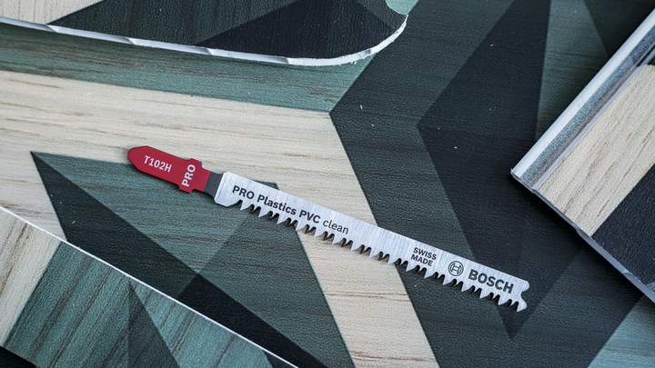 Jigsaw blade for cutting plastic and laminate panels on a patterned work surface.