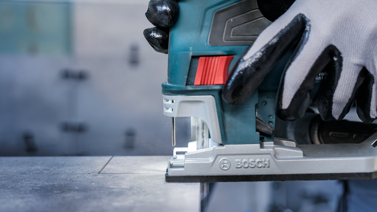 PRO Soft Tile T130RF Jigsaw Blade, 83 mm, 3 pcs Person wearing safety equipment uses a jigsaw to cut a straight line in a metal sheet.