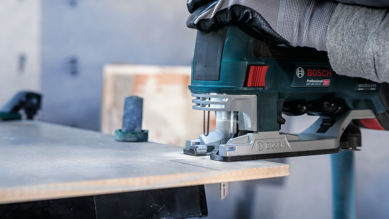 PRO Soft Tile T130RF Jigsaw Blade, 83 mm, 3 pcs Person wearing safety equipment cuts wood with a power jigsaw.