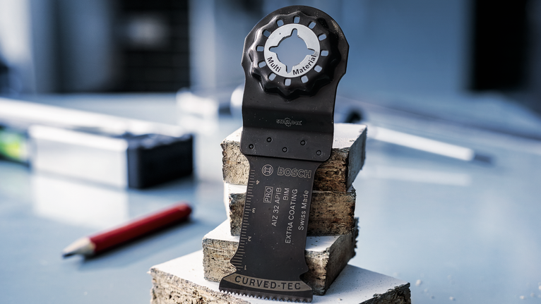 PRO AIZ 32 APIB Plunge Cut Blade, 32 x 50 mm Oscillating saw blade stands upright on stacked concrete blocks in a workshop.