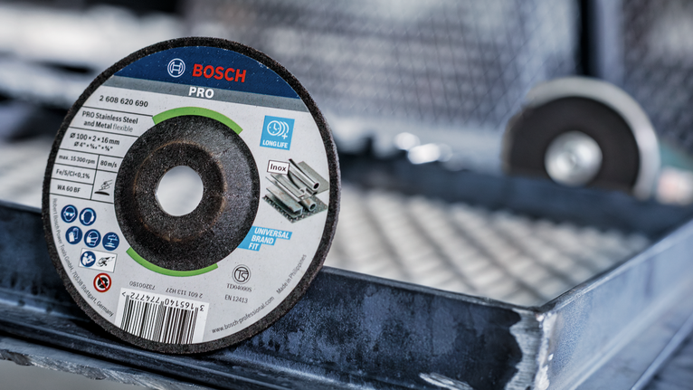 PRO Semi-Flexible Grinding Disc, 100 x 2 x 16 mm Cutting disc with product labels displayed, resting on a metal surface.