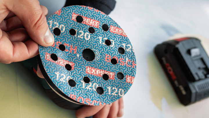 Object #200471071: 7390919_app_web_2 Round sanding disc being attached to an orbital sander.