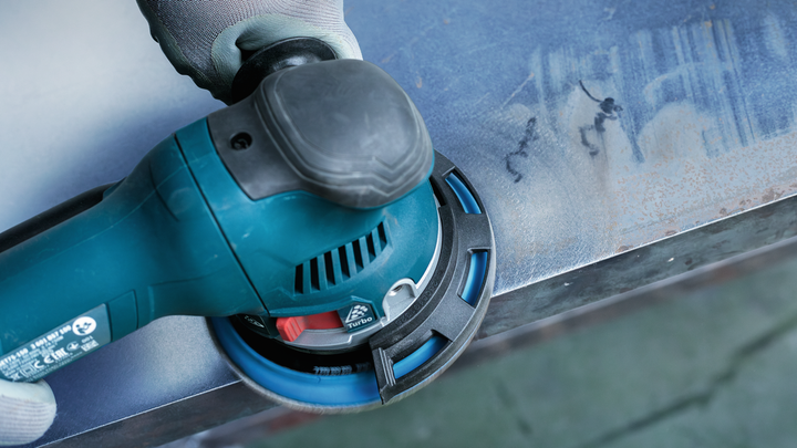 Object #200471074: 7390919_app_web_5 Gloved hand using an electric sander to smooth a metal surface.