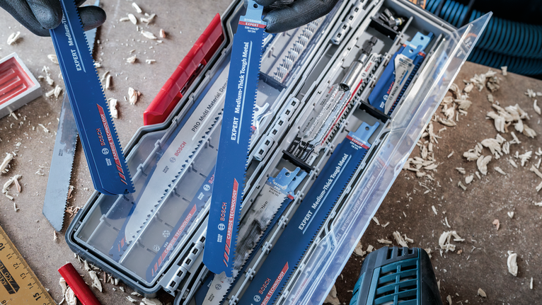 PRO Tough Box Large for Accessories, 50 x 120 x 355 mm Person wearing safety equipment selects a reciprocating saw blade from a storage case.