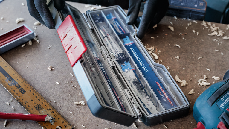 PRO Tough Box Large for Accessories, 50 x 120 x 355 mm Person wearing safety equipment opens a case of saw blades on a workbench.