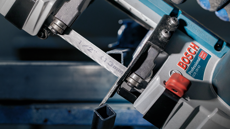 PRO CB2824 Band Saw Blade, 733 mm, 2 pcs Metal bandsaw cutting through a square steel tube in a workshop.