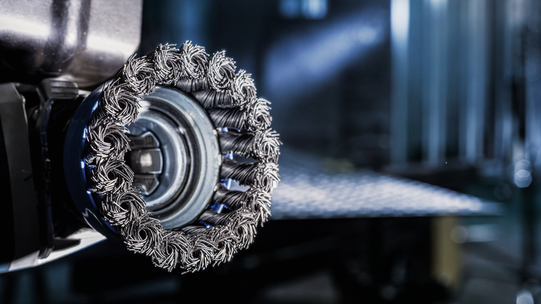 PRO Stainless Steel heavy X-Lock Cup Brush, 75 x 0.5 mm Wire wheel brush mounted on a power tool ready for metal surface cleaning.