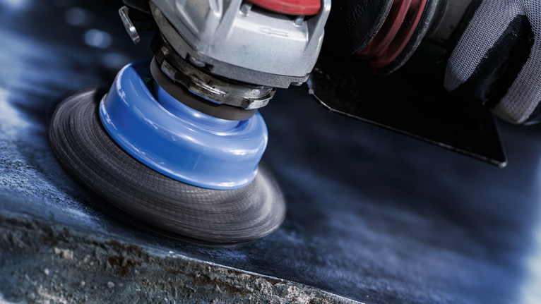 PRO Stainless Steel clean X-Lock Cup Brush, 75 x 0.3 mm A person wearing safety equipment polishes a metal surface with a power tool.
