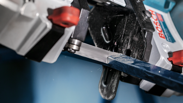 PRO CB281418 Band Saw Blade, 733 mm, 2 pcs Bandsaw slicing through a metal bar in a close-up industrial setting.