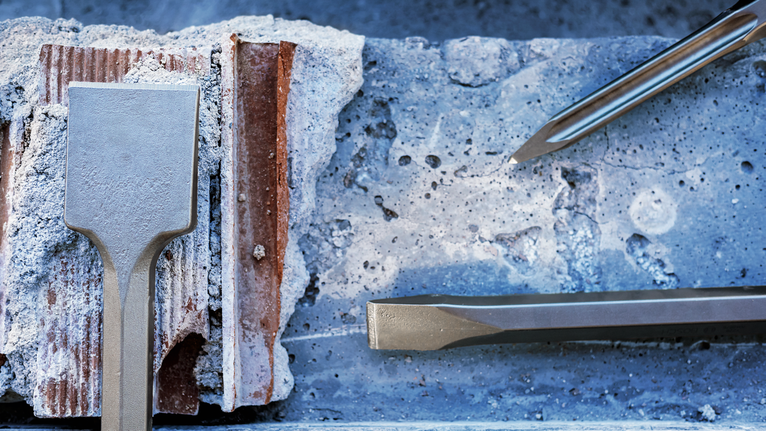 PRO HEX-4C Flat Chisel 28 mm, 35 x 400 mm Chisels breaking through a concrete block at a construction site.
