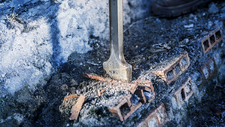 PRO HEX-4C Flat Chisel 28 mm, 35 x 400 mm Flat chisel breaking bricks on a rough concrete surface.