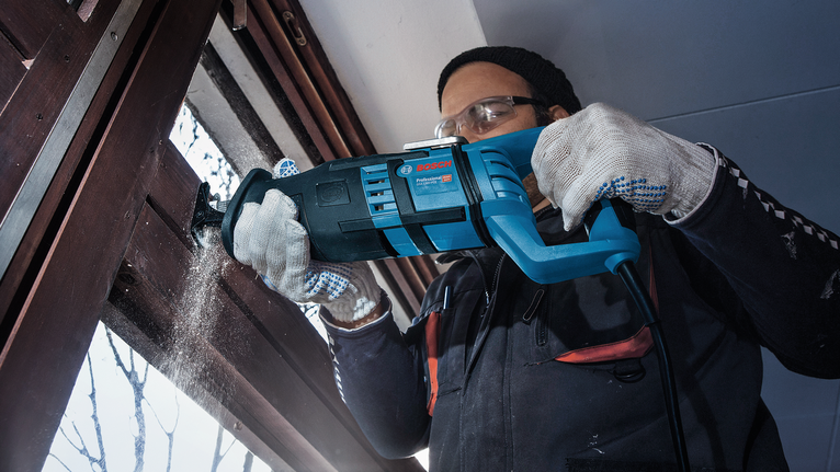 PRO Window Demolition S611DF Blade, 1.25 x 19 x 150 mm, 2 pcs A person wearing safety equipment uses a reciprocating saw to cut a wooden window frame.