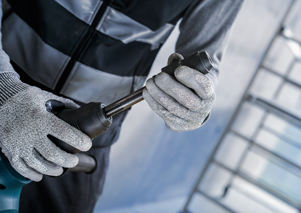 PRO Hammer Adapter, SDS max to SDS plus Person wearing safety equipment attaches a metal bit to a power tool.