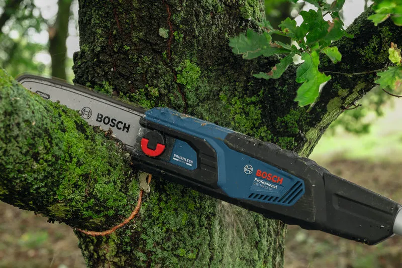 GKE 18V-25 TP Cordless telescopic pruner cutting a mossy tree branch outdoors.
