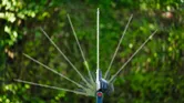 Cordless telescopic hedgecutter showing adjustable cutting angles outdoors.