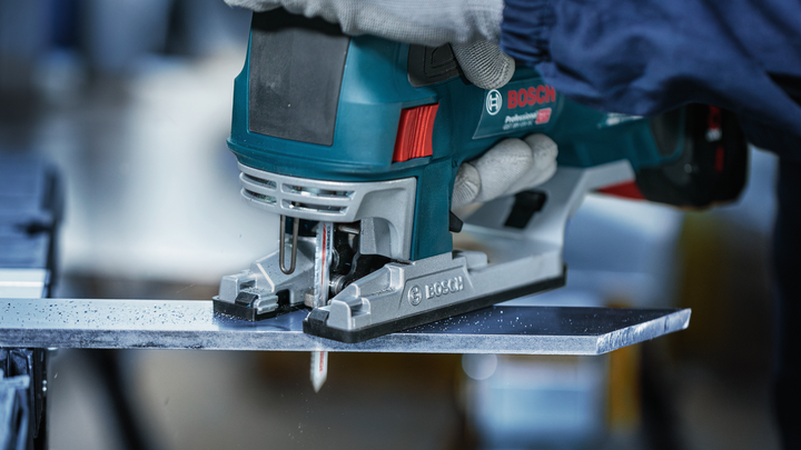 Object #200559110: 7478951_app_web_1 Worker wearing safety equipment uses a jigsaw to cut through a sheet of metal.
