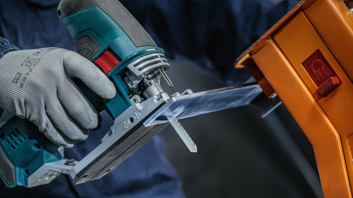 Object #200559118: 7478951_app_web_8 A worker wearing safety equipment cuts plastic with a jigsaw.