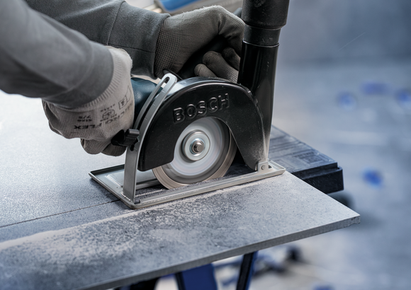 Object #200573114: 7562634_app_wide_5 Person wearing safety equipment operates a circular saw to cut a tile.