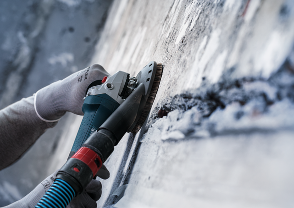 Object #200573503: 7743905_app_wide_3 Person wearing safety equipment polishes a concrete wall with a power tool.