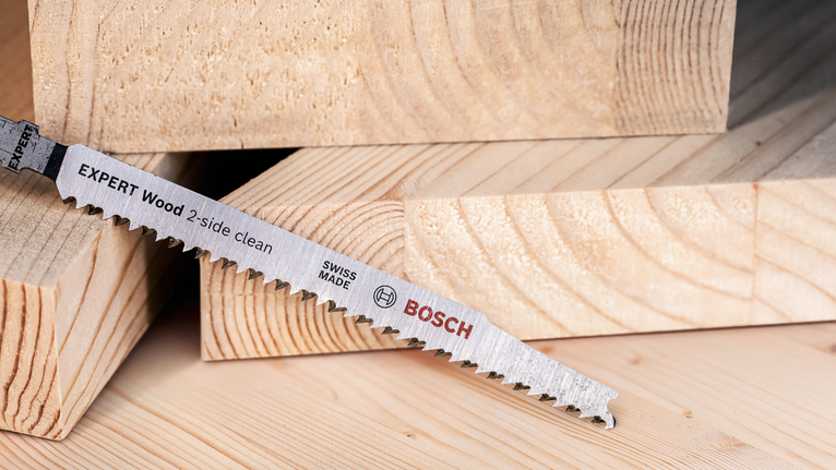 EXPERT ‘Wood 2-side clean’ T 308 B Jigsaw Blade 5-pc Saw blade resting on stacked cut timber pieces.